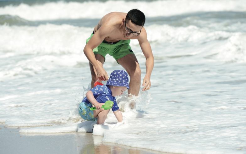 Rodrigo juega en el mar con su pequeño hijo