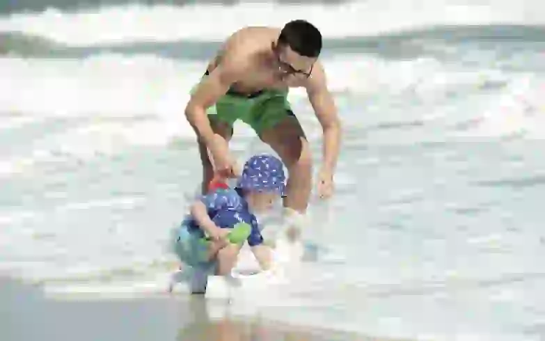 Rodrigo juega en el mar con su pequeño hijo