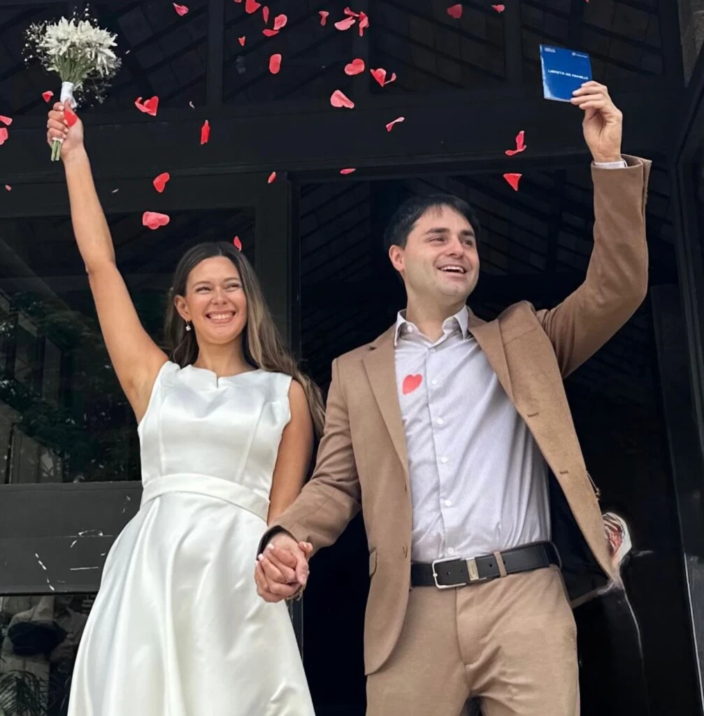 CANDALAFT Y MARIELA SALUDAN TRIUNFALES Y LIBRETA EN MANO TRAS SALIR DEL REGISTRO CIVIL CONVERTIDOS EN MARIDO Y MUJER.