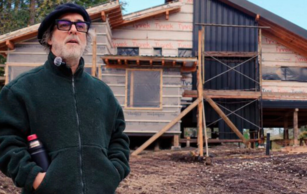 MEX EN PRIMER PLANO, Y DETRAS SUYO LA CASA QUE SE ESTA CONSTRUYENDO EN BARILOCHE. SE FUE A VIVIR ALLA.